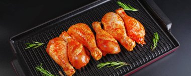 Baharatlı et pankartı için arka plan. Baharatlı çiğ tavuk eti bacağı ve siyah arka plan için baharat. Harika bir manzara. Konforlu yemekler, önceden pişirilmiş..