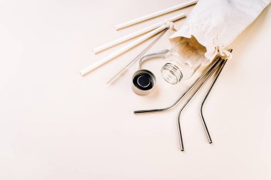 Sıfır atık ve çevre dostu, plastiksiz kavram. Beyaz arka planda yeniden kullanılabilir cam şişe. Pamuk torbası, cam şişe ve metal yeniden kullanılabilir ve kağıt kullanılabilir tüpler.