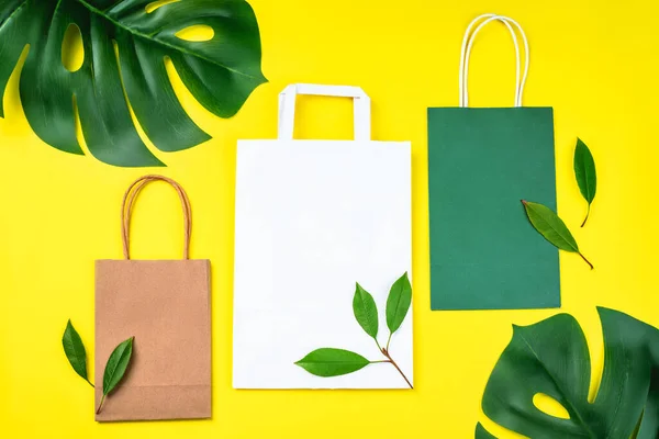 Bolsa de compras de papel reciclado con hojas verdes. Zero waste, plastic-free concept.Protección del medio ambiente, vida sostenible.Conjunto de múltiples bolsas de papel desechables para llevar alimentos, regalos y maquetas. — Foto de Stock