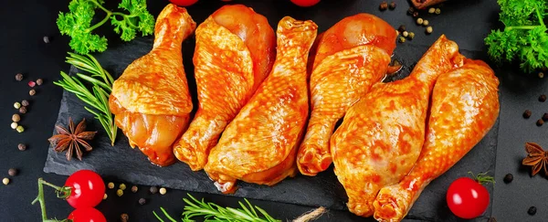 Kényelmi élelmiszer, előző.Nyers pácolt csirkeláb fűszerekkel a főzéshez BBQ sötét háttér. Felülnézet. — Stock Fotó