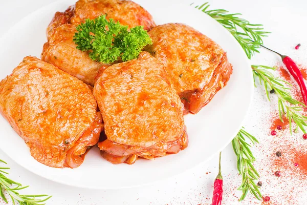 Куриные бёдра маринуются в красном соусе на белой тарелке, на белом фоне, баннер. Удобная еда, быстрый повар, полуфабрикаты. — стоковое фото