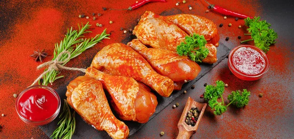 Convenience food, precooked.Raw Marinated chicken meat legs with spices for cooking for BBQ dark background. Top view.