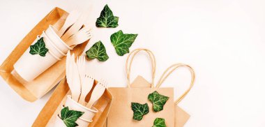 Eko-el yapımı kağıt sofra takımı, fincanlar, fast food kapları. Geri dönüşüm, çevre dostu konsept. Atılabilir eko çatal bıçak takımı, tabaklar, kaşıklar, bıçaklar, çatallar hafif bir arka planda. Yiyecek teslimatı için kağıt torba..