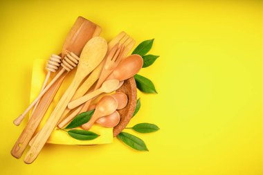 Sarı bir arka planda, kağıt tabağa sıkıştırılmış tek kullanımlık çatal bıçak takımı. Bambu ahşap ve kağıttan yapılmış çevre dostu tek kullanımlık çatal, çatal, bıçak, bambu kaseleri ve diğerleri. Boşluğu kopyala.