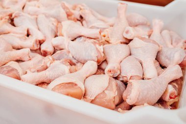 Taşıma bandı yiyeceği. Et fabrikası. Modern gıda fabrikasındaki üretim hattı. Çiğ tavuk budu içeren konteynerler..