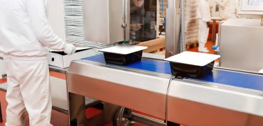 Production process, packaging on the conveyor line of meat in boxes.Conveyor Belt Food.Automated production line in modern food factory.People working.Chicken fillet production line.