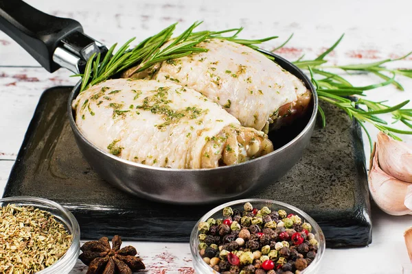 Raw chicken thighs marinated in herbal sauce with fresh rosemary, spices. Chicken thighs with spices, garlic. — Stok fotoğraf