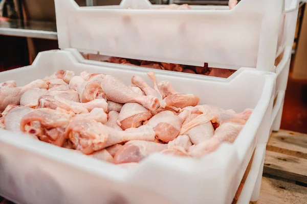 Manufacturing process.Conveyor Belt Food.Automated production line in modern food factory.Containers on a conveyor line with raw chicken drumstick.Factory for the production of food from meat,poultry.