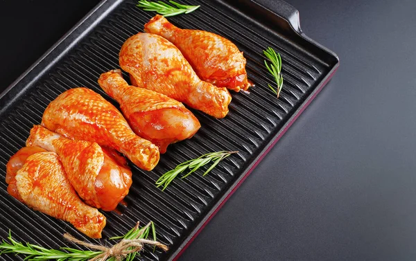 Uygun yemek, önceden pişirilmiş. Baharatlı çiğ tavuk eti bacağı ve barbekü koyu arkaplan için pişirme. Üst görünüm. Boşluğu kopyala.