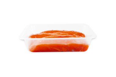 Kırmızı soslu marine edilmiş tavuk filetosu izole bir arka planda şeffaf bir tepside. Yan görüş. Mekanı kopyala. Fast food, evde yemek..