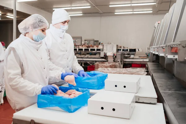 Linea di produzione automatizzata con confezionamento e taglio di carne nella moderna industria alimentare.Attrezzature per la lavorazione della carne. Linea di produzione di filetti di pollo di carne alimentare in imballaggi in plastica sul trasportatore. — Foto Stock