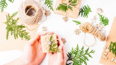 Kızların elleri hediyelerden bir kompozisyon yapıyor. Noel evi dekorasyonu. Poster. Basit minimalist Noel evi süsü..