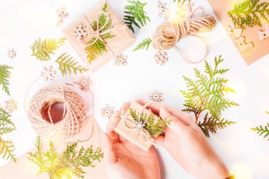 Kız elleri hediyelerden bir kompozisyon oluşturur. Noel evi dekorasyonu. Basit minimalist Noel evi dekorasyonu..