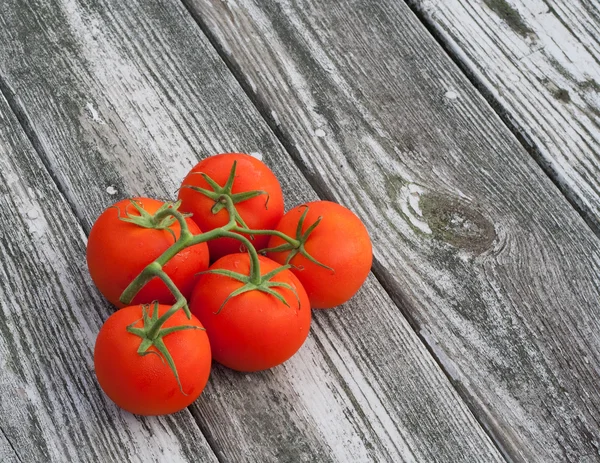 Tomates de videira no fundo de madeira velha — Fotografia de Stock