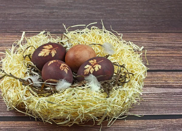 Nido con uova di Pasqua su sfondo di legno — Foto Stock