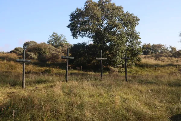 第二次世界大戦中にオランダのヴァールドルパーテ湖で抵抗軍のメンバーが撃たれた記念碑の上に青銅製の十字架 — ストック写真