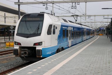 Hollanda 'daki Zwolle İstasyonu platformu boyunca Keolis' ten Enschede 'e giden Stadler Flirt 3 treni