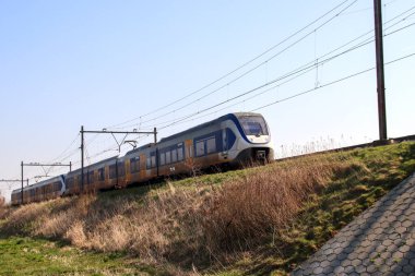 Yerel SLT Sprinter treni Nieuwerkerk aan den IJssel Hollanda 'da bir yamaçta
