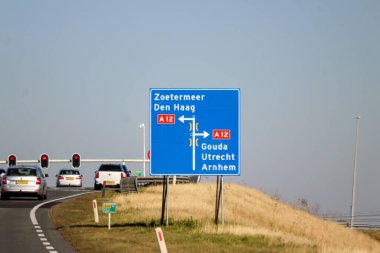 Hollanda, Zevenhuizen 'deki N219 yolunun mavi yönü ve bilgi işareti.