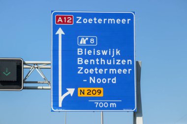 Hollanda 'daki Zoetermeer ve Lahey' e giden A12 numaralı otobandaki istikamet için mavi yön ve bilgi işareti.
