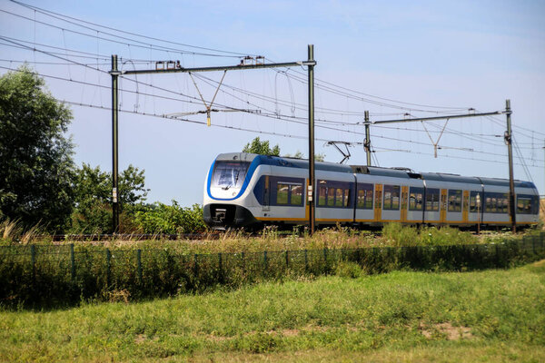 Местный пригородный поезд на пути в Moordrecht направляясь в Роттердам в Нидерландах.