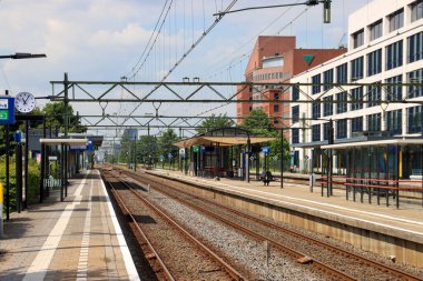 Hollanda 'daki Den Haag Mariahoeve istasyonundaki platformlar, binalar ve raylar