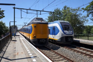 SLT train arriving and ICM intercity rushing at the train station of Nieuwerkerk aan den IJssel in the Netherlands