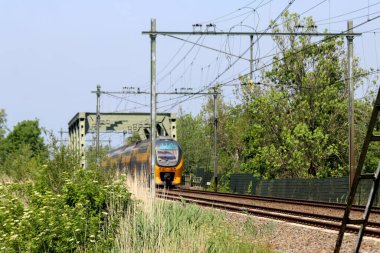 VIRM doubledecks intercity train along the rail bridge at Kethel in schiedam in the Netherlands