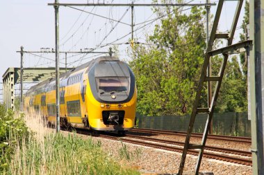 VIRM doubledecks intercity train along the rail bridge at Kethel in schiedam in the Netherlands