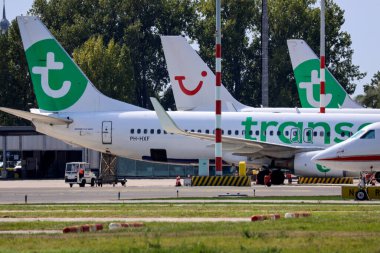 PH-HXF Transavia Boeing 737-8K2 (WL) Rotterdam apronunda Lahey Havalimanı 'nın arka planında TUI kuyruğu ile