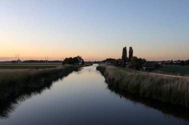 Moerkapelle 'deki Rotte Nehri' nin başlangıcında gün batımı Hollanda 'daki Rotterdam' a doğru ilerliyor.
