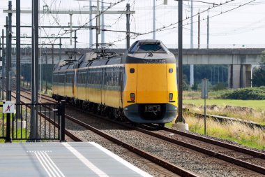 Koploper adlı ICM Intercity treni Hollanda 'daki Lansingerland Zoetermeer istasyonunda hızla ilerliyor.