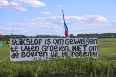 Hollanda 'nın Krimpenerwaard belediyesindeki N210 boyunca Lekkerkerk' te protesto işaretleri ve sıra sıra bayraklar baş aşağı