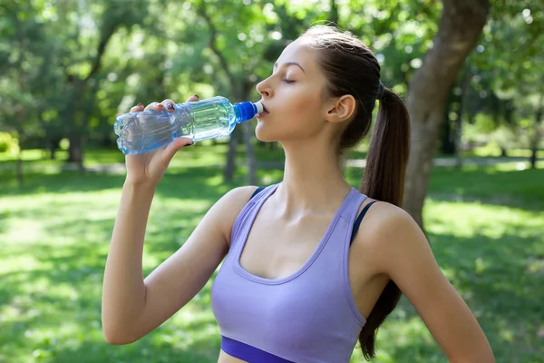 美しい少女スポーツの後の水を飲む — ストック写真