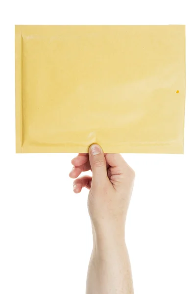 Gele envelop in de hand — Stockfoto