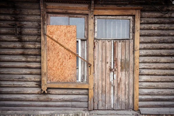 Boarded up windows and old door — Stock Photo, Image