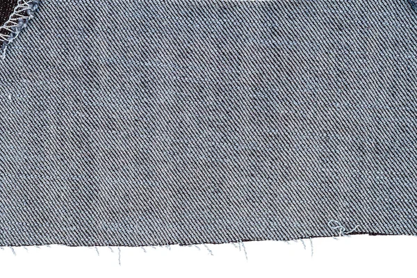 白い背景に隔離された青いジーンズ生地のピース 凹凸のあるエッジ デニムジーンズが裂けた ジーンズ生地の裏側 — ストック写真