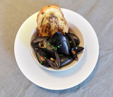 Bir kase dolusu haşlanmış midye ve bir dilim kızarmış ekmek..