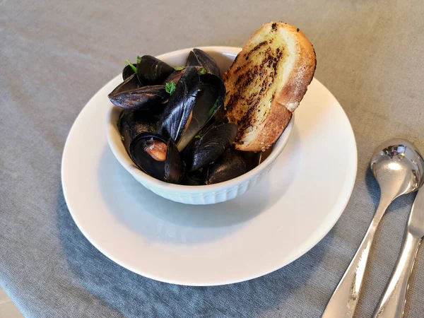 Bir kase dolusu haşlanmış midye ve bir dilim kızarmış ekmek..