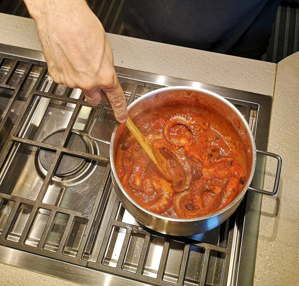 Ahtapot tencerede pişiyor. Ahtapot ve domates soslu karides..