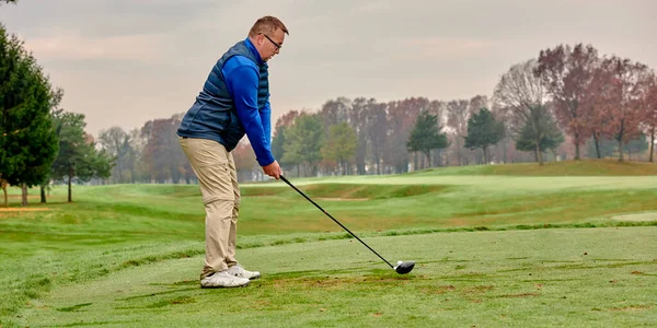 Golfer on a golf course, ready to tee off. Golfer with golf club hitting the ball for the perfect shot.