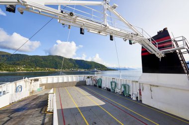 Norveç Denizi 'nde bir feribotun içi boş, arka planda güneşli bir günde Norveç fiyortunun kıyıları..