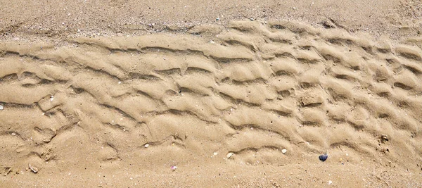 Sand texture. Sand bottom by the sea. Sea sand bottom in the shape of waves.