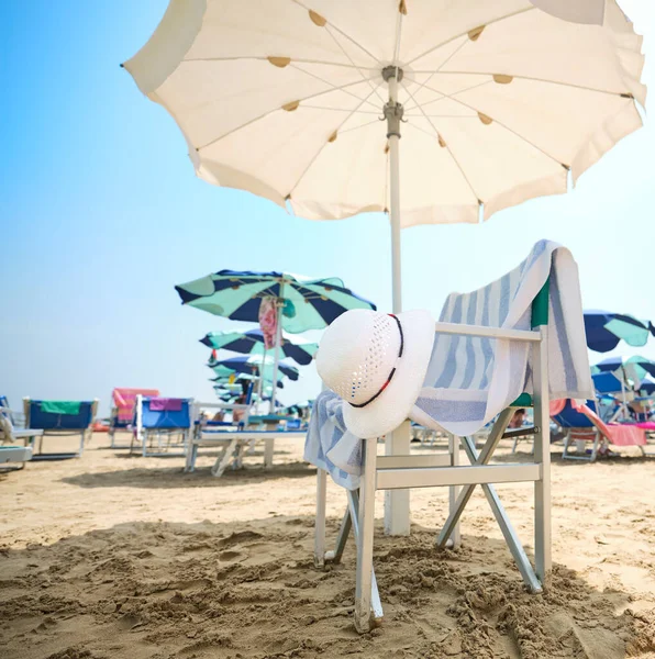 Chair White Straw Hat Striped Towel Beach Umbrella Sunny Summer — Stok fotoğraf