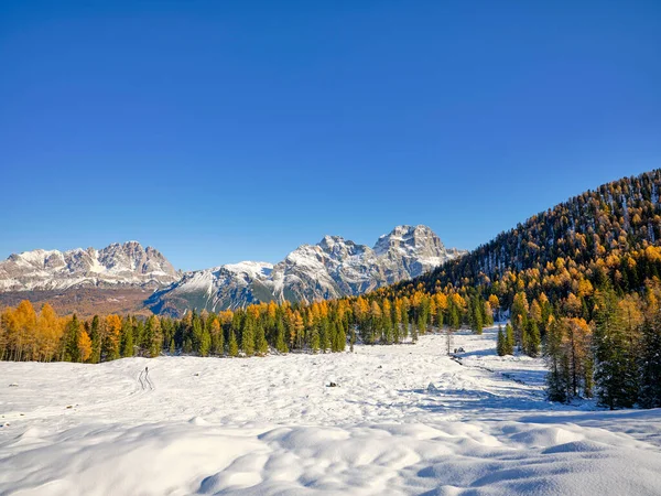 Snowy autumn landscape in the woods of the Dolomites, overlooking the Sorapiss Massif and Monte Cristallo in Cortina d\'Ampezzo, Veneto, Italy, Europe. Range with characteristic peaks, wooded areas and lakes, a popular place for hiking with snowshoes