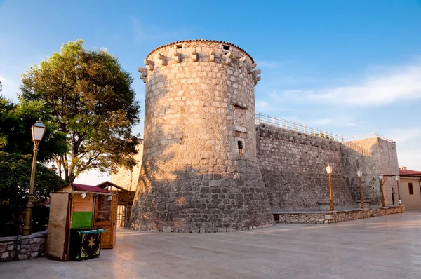 Paredes de la torre de la fortaleza de Frankopan y pequeña tienda de madera en Krk - C —  Fotos de Stock