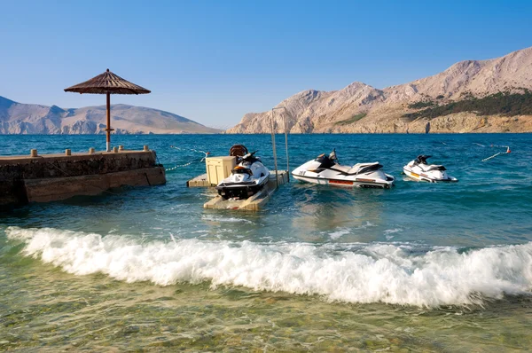 Güneşlik iskeleyakınında Baska de deniz kıyısında üç watercrafts - — Stok fotoğraf