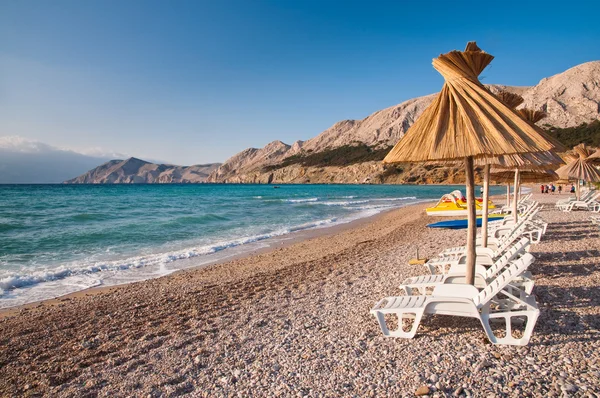 Parasolka i leżak na plaży w miejscowości baska, Krk - Chorwacja — Zdjęcie stockowe