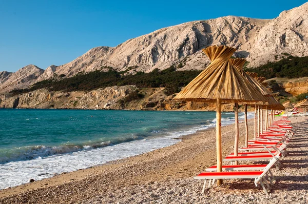 Pare-soleil et chaises longues orange sur la plage de Baska - Krk - Croate — Photo