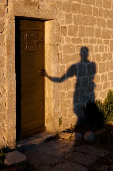 Sombra do homem que abre a porta em Lubenice — Fotografia de Stock
